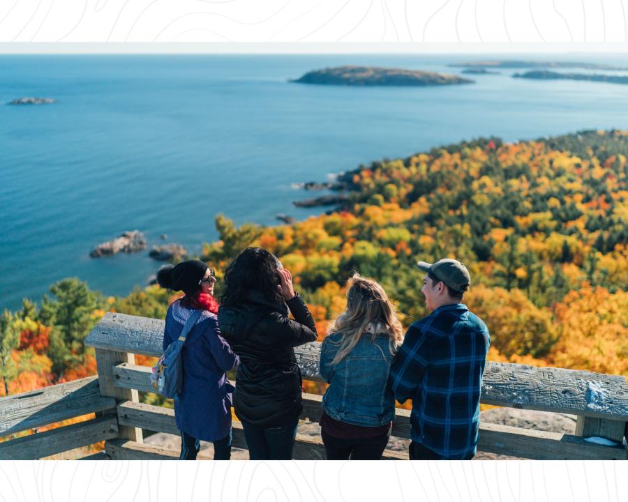 A group of friends overlooking Lake Superior on an observation deck on top of Sugarloaf Mountain in Marquette, MI