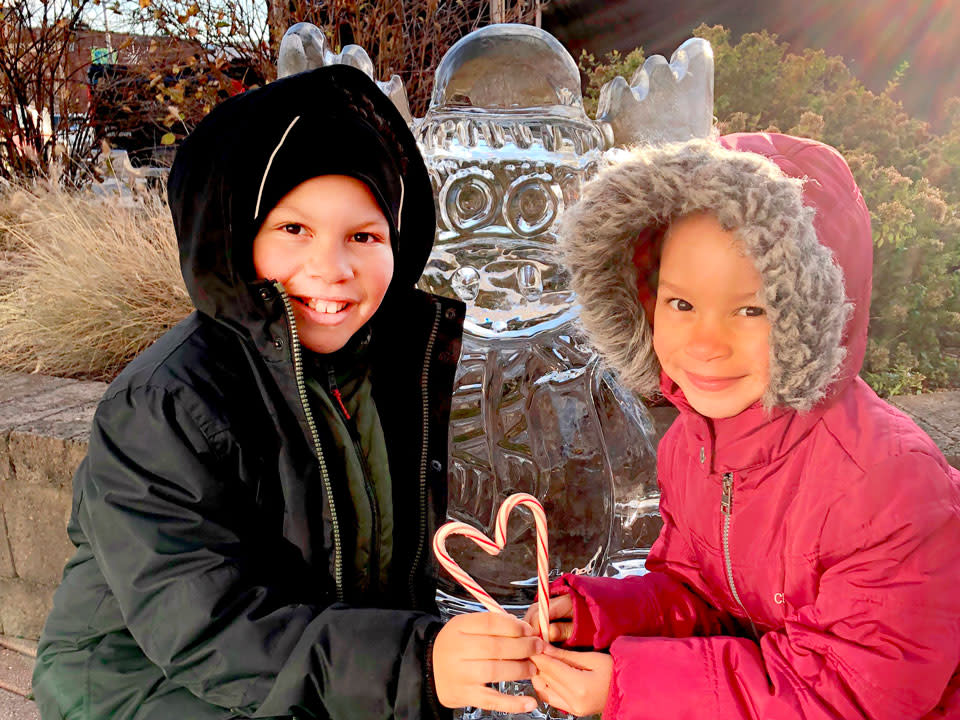kids holding Candy can in hand in front of Ice Sculpture