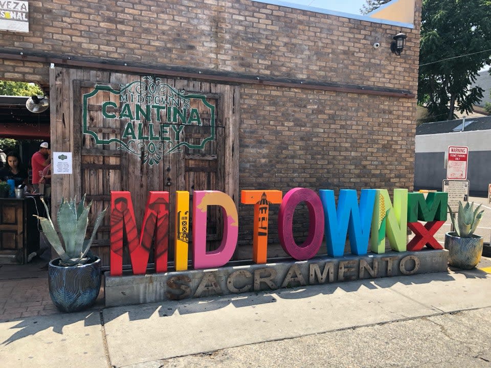 colorful sign that says midtown sacramento in front of cantina alley