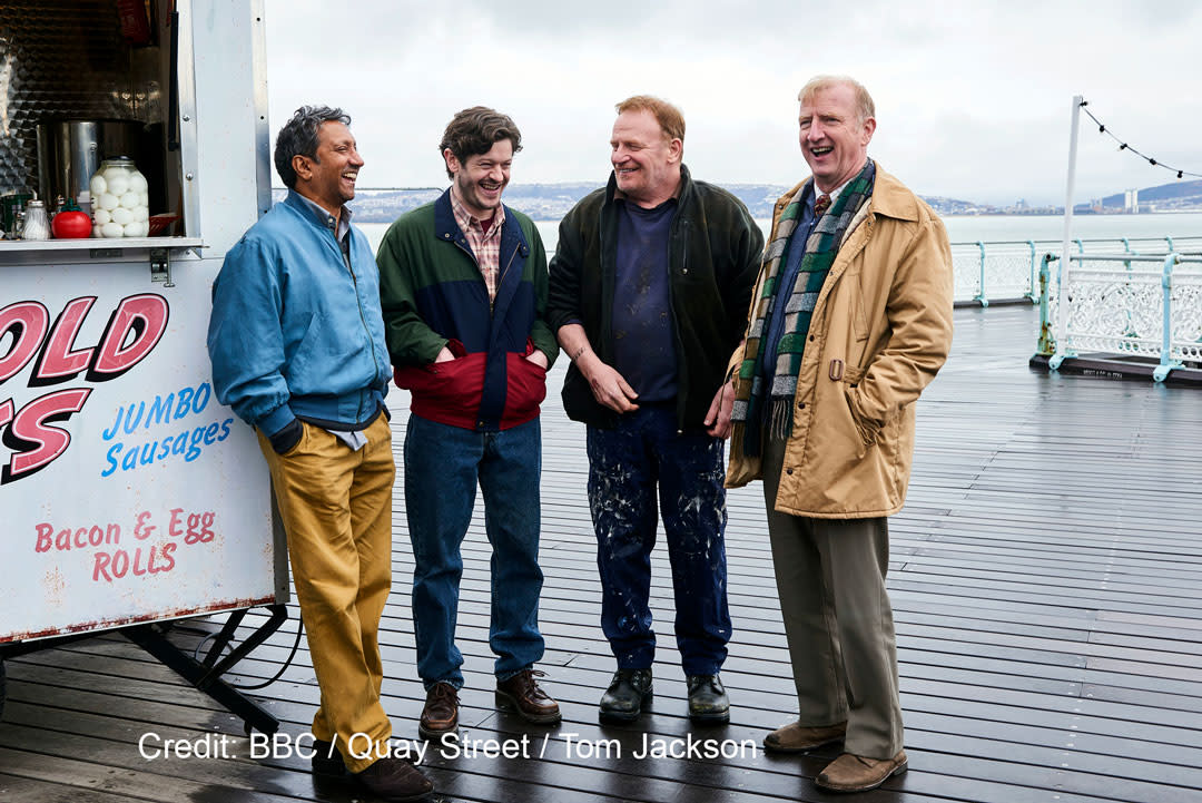 Four actors from men up laughing on Mumbles Pier.