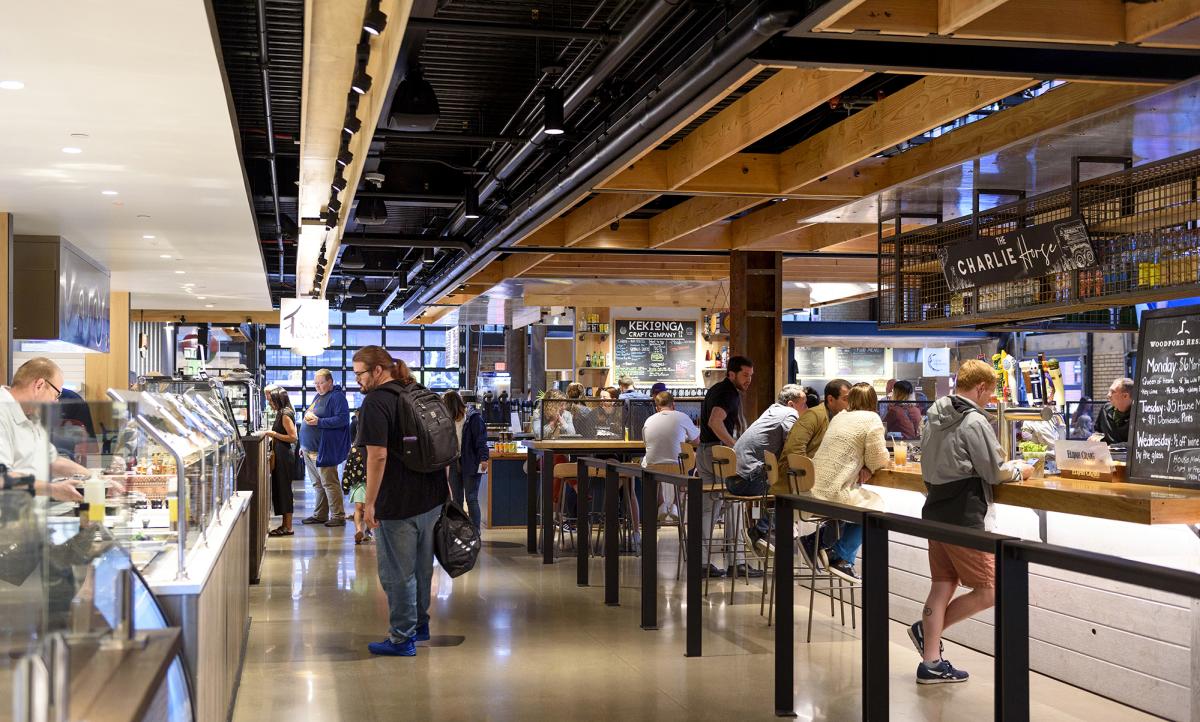 people browse the vendors at a food hall