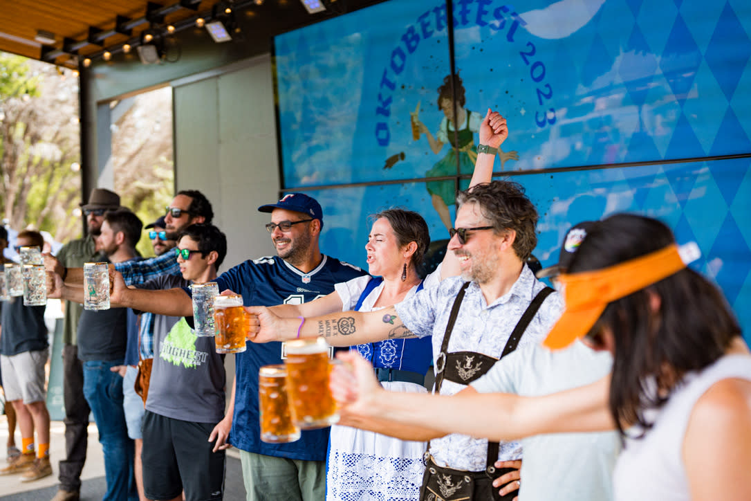 Image of a group of people on stage at Meanwhile Brewing holding up a stein of beer.