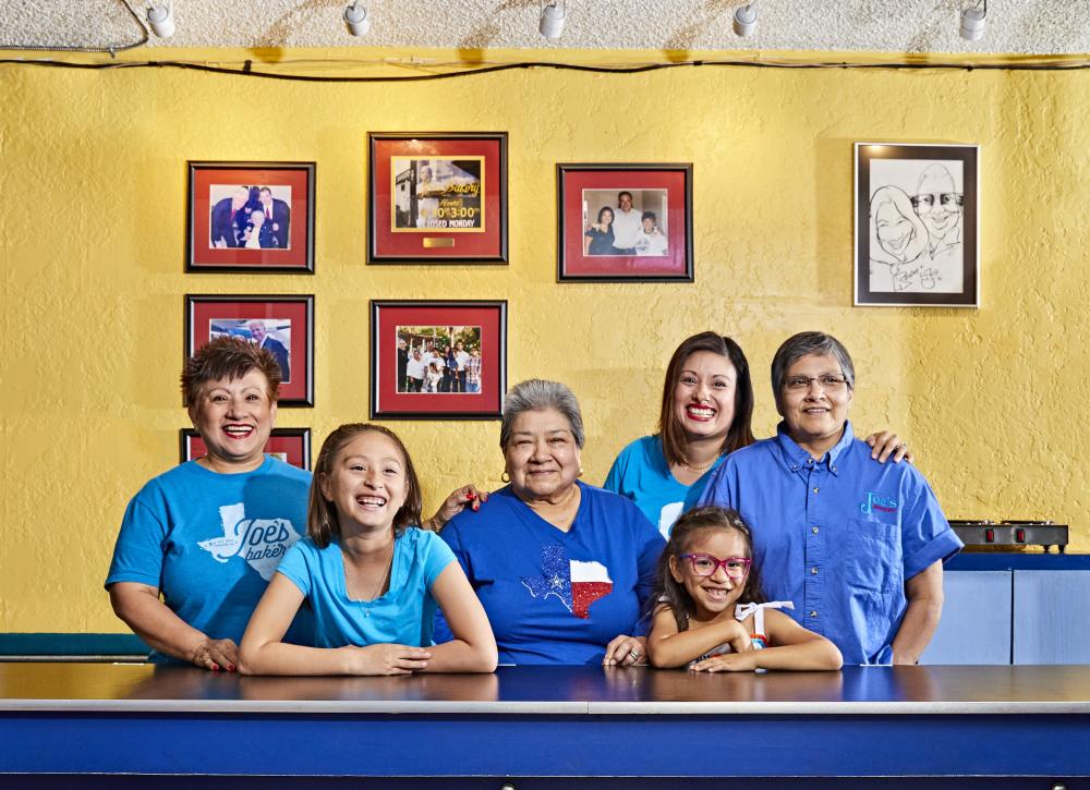 Regina Estrada and female family members smile for a portrait inside Joes Bakery and Coffee Shop