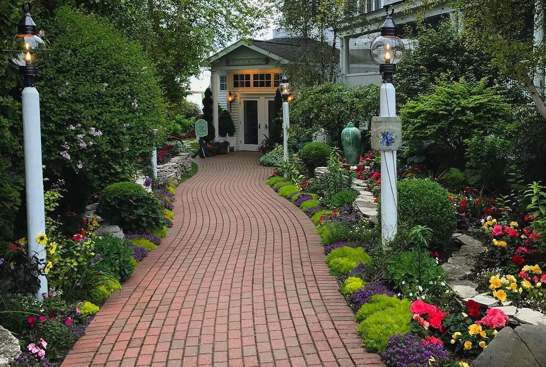 Brick paver pathway leading through garden to door of Carriage House restaurant on Mackinac Island