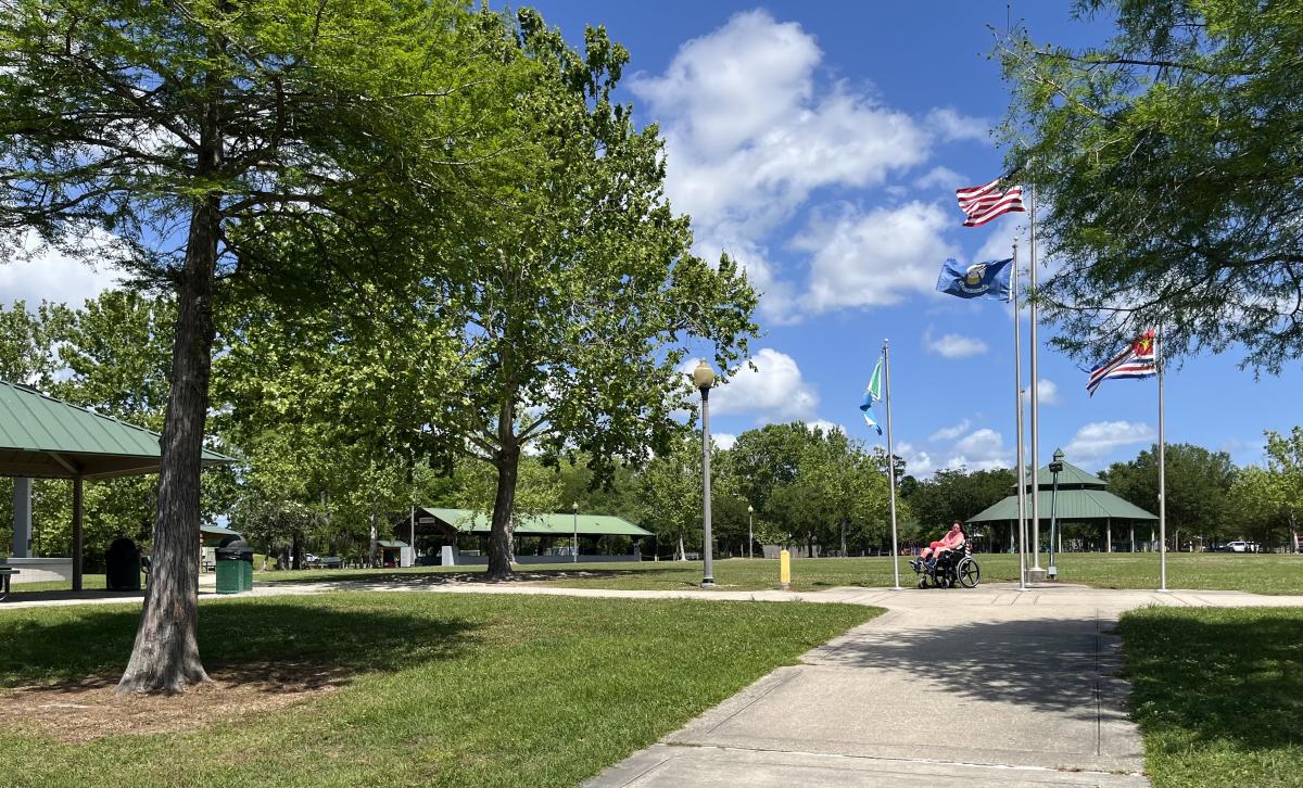 PJ Paulsell enjoys the paved pathways and open green spaces at Heritage Park in Slidell near the park's picnic pavilions and flag plaza.