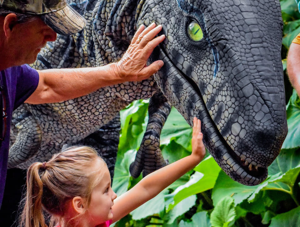 A person holding a dinosaur prototype