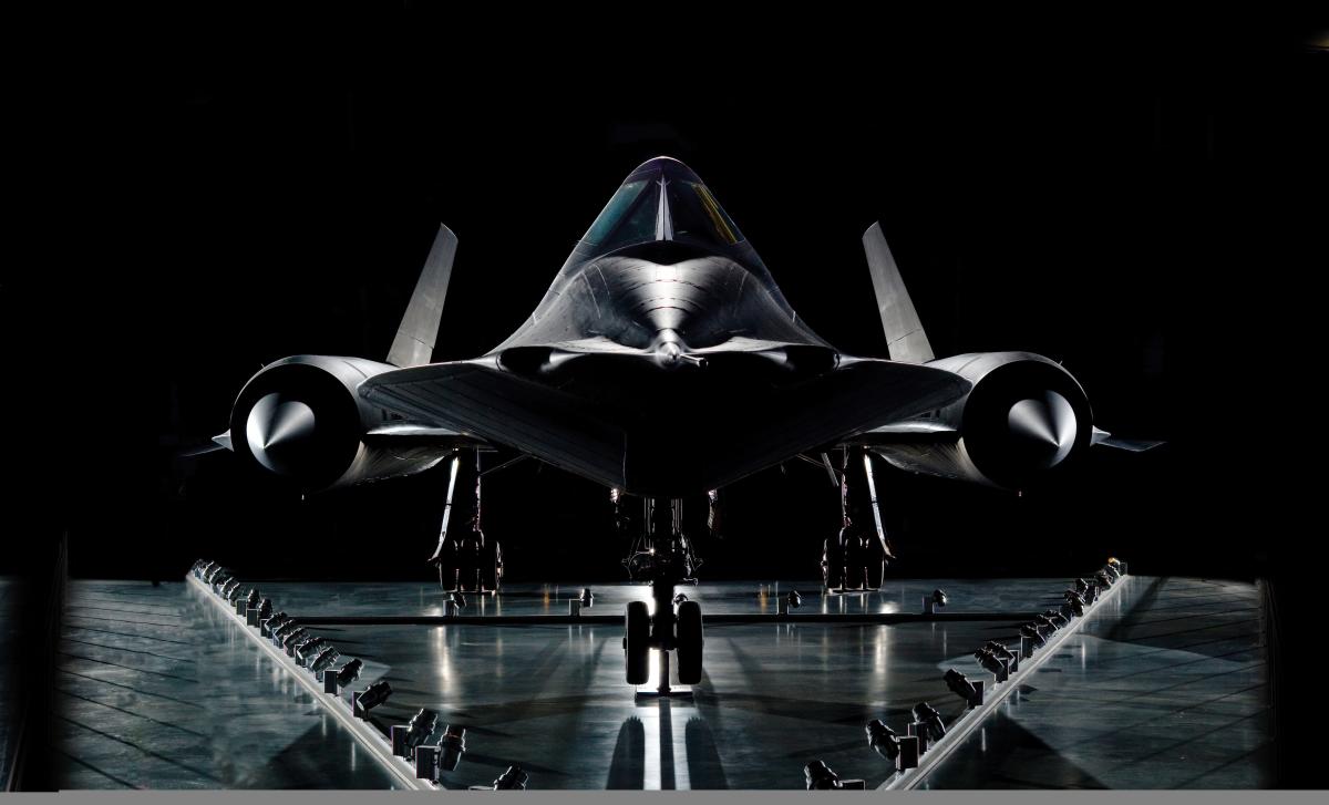 Dramatic shot of the SR71-Blackbird with light shining off the plane against a background of dramatic black