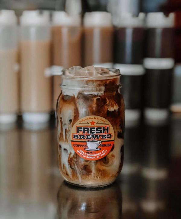 Mason jar filled with coffee and clouds of cream with the logo for Fresh Brewed Coffee House, Myrtle Beach, SC