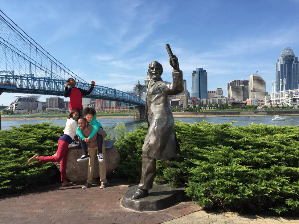 Family taking photo by the John A. Roebling bronze statue (photo: CincinnatiUSA.com)