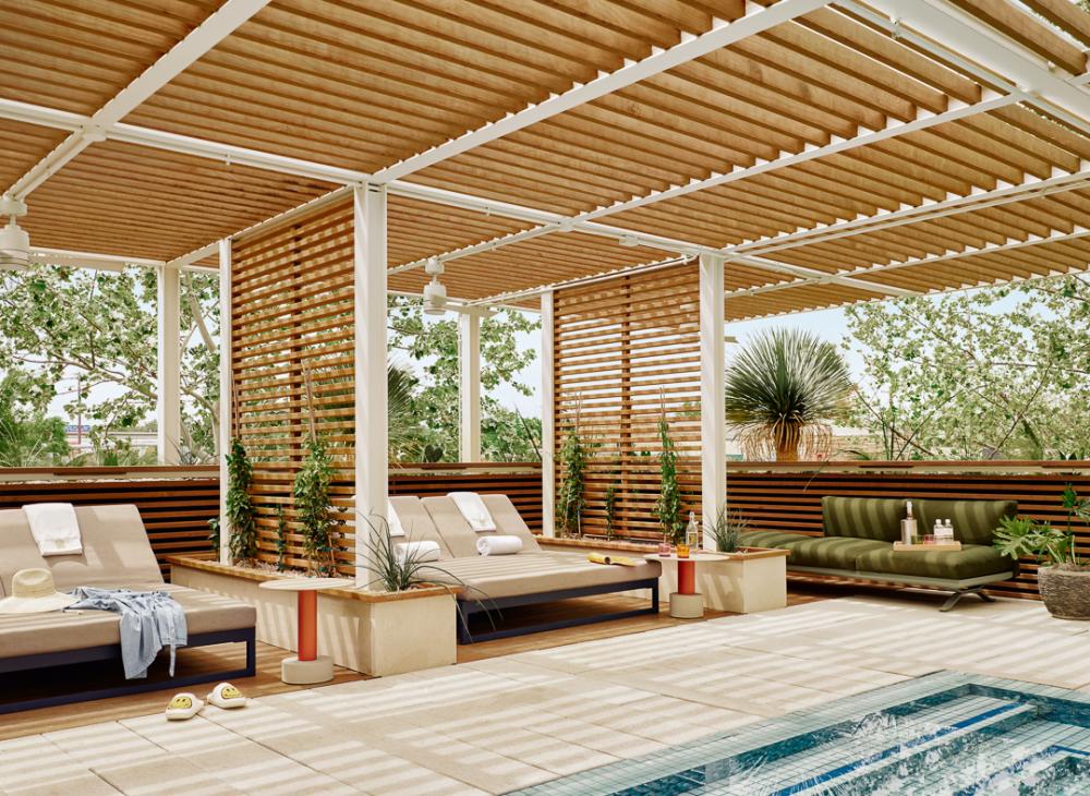 Poolside cabanas with large lounge furniture, and clothes and towels draped across the lounge chairs.