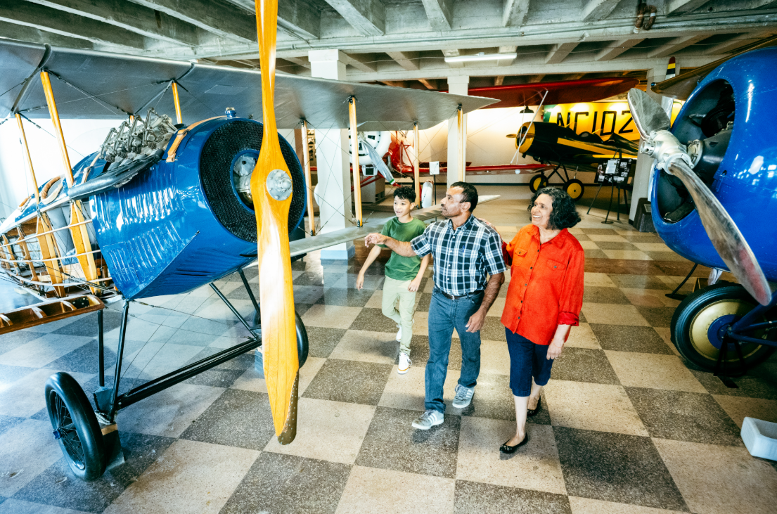 A mother, father and boy look at a plane on exhibit at the Kansas Aviation Museum.