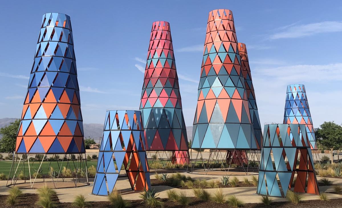 Various cone-shaped towers in shades of blue, orange, red and pink located at a park in Indio.