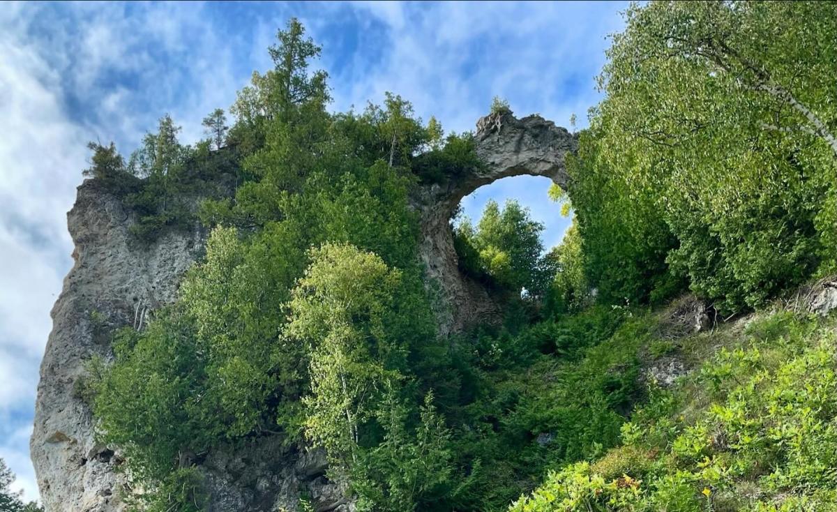 Mackinac Island’s Arch Rock as seen from below with blue sky visible through the arch