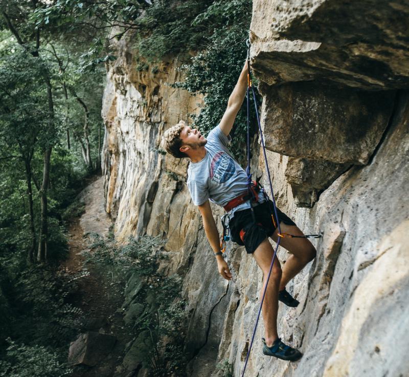 young man climbing a rock