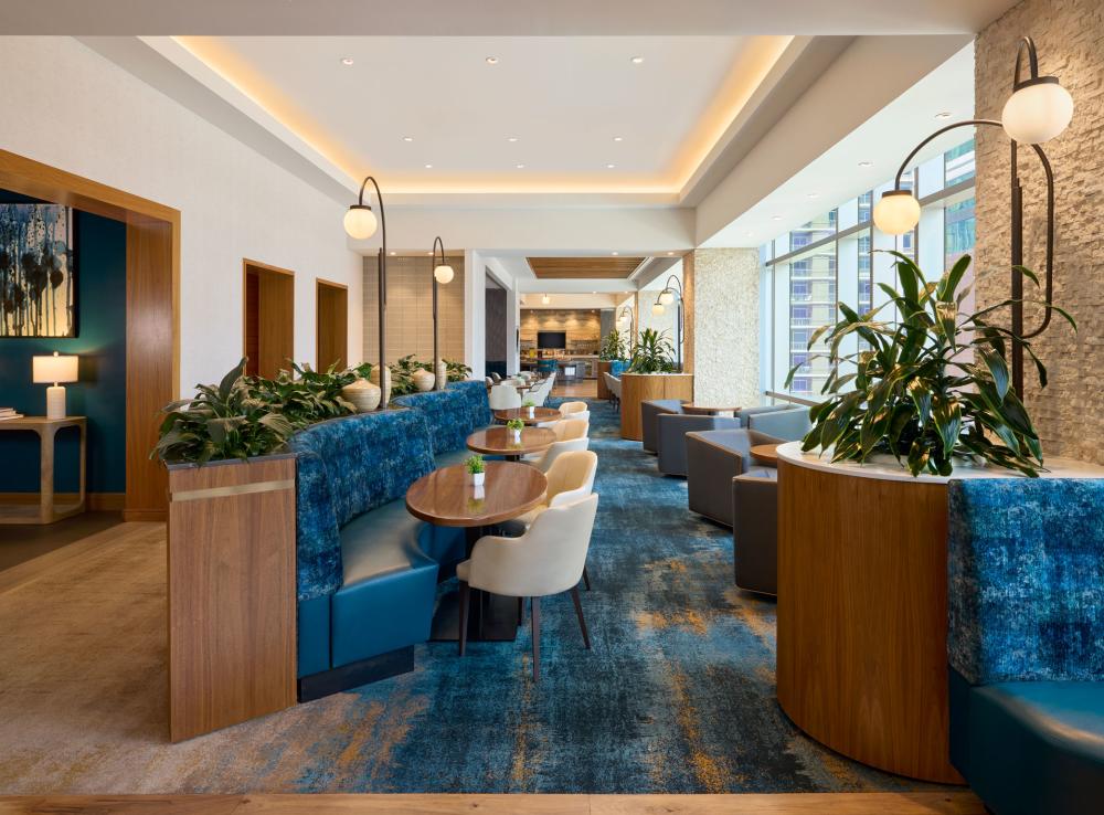 Photo of the renovated dining room space at JW Marriott with blue banquette seating and blue carpeted floors.