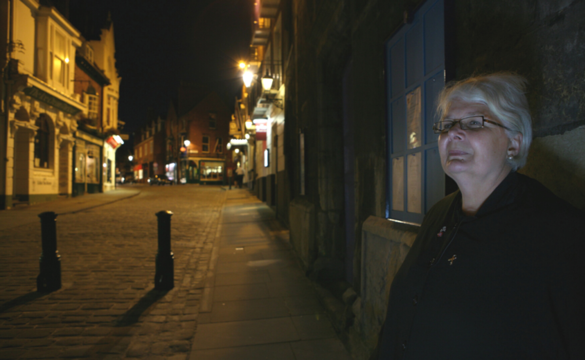 A woman walking the streets of Lincoln on a Ghost Walk