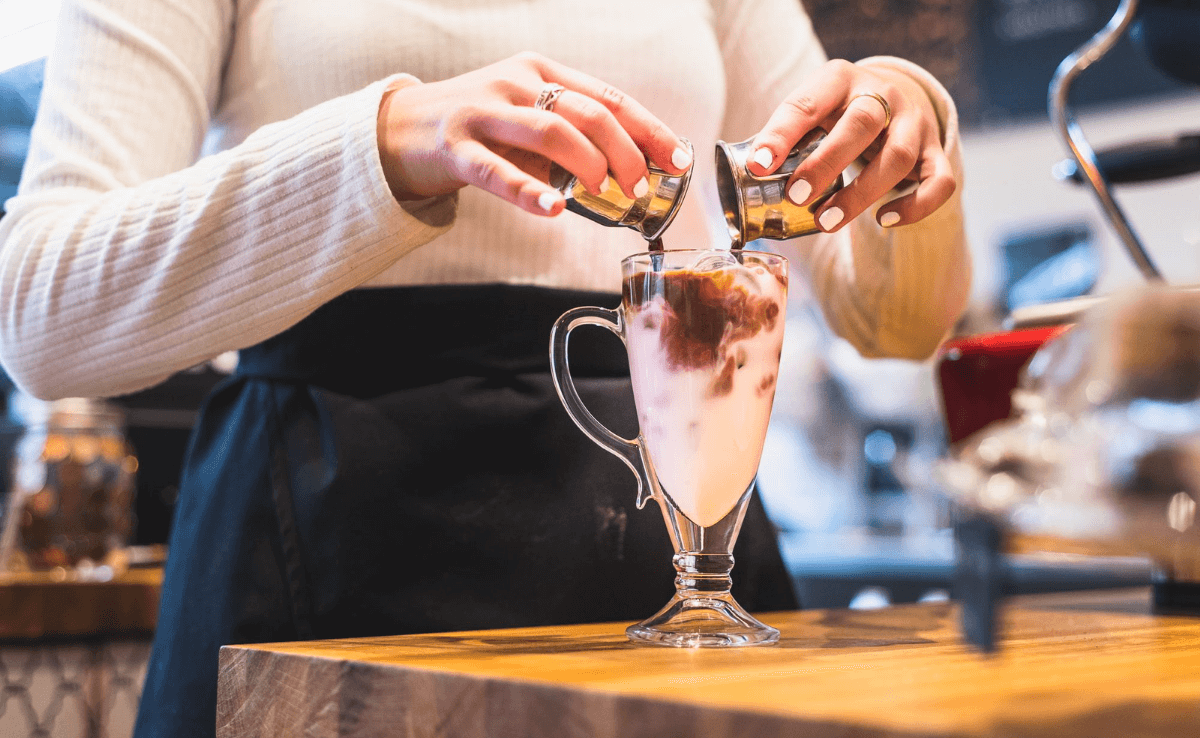woman pouring chocolate into a glass of milk