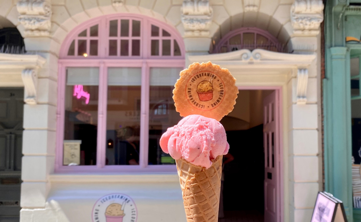 Ice cream cone being held up outside of an ice cream shop in Lincoln