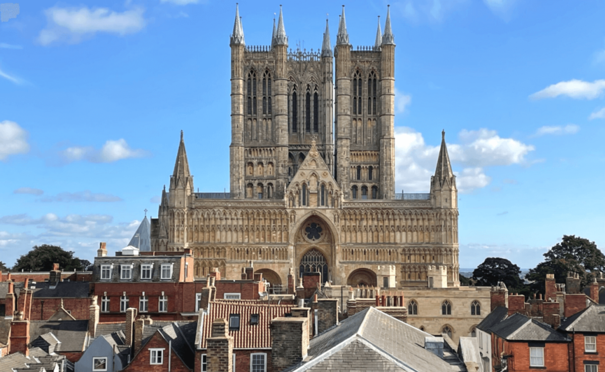View of Lincoln Cathedral and its three towers over roof tops in Lincoln