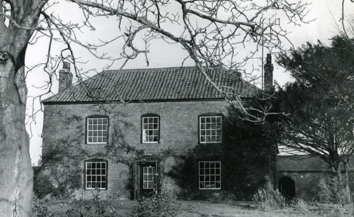 a black and white photo of Twiggmore Hall with trees surrounding the area around the house