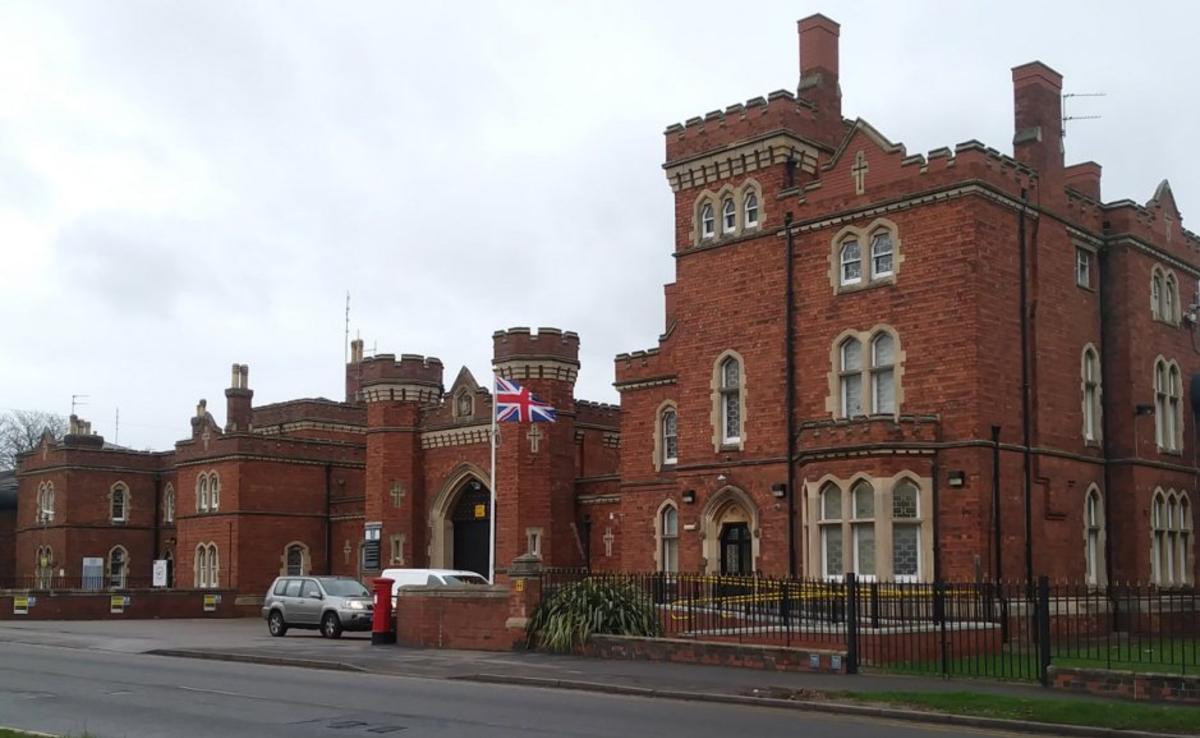 A view of Lincoln Prison, a historic red brick building with elaborate windows