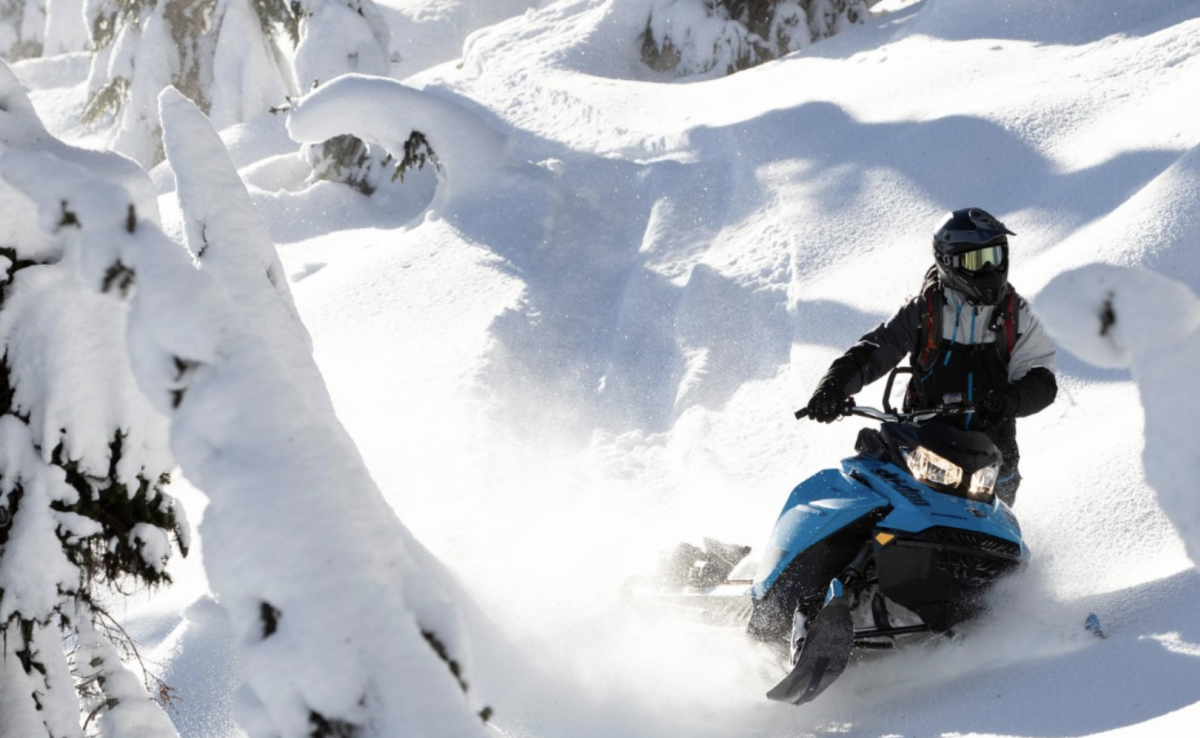 Snowmobiler in deep powder snow in Utah