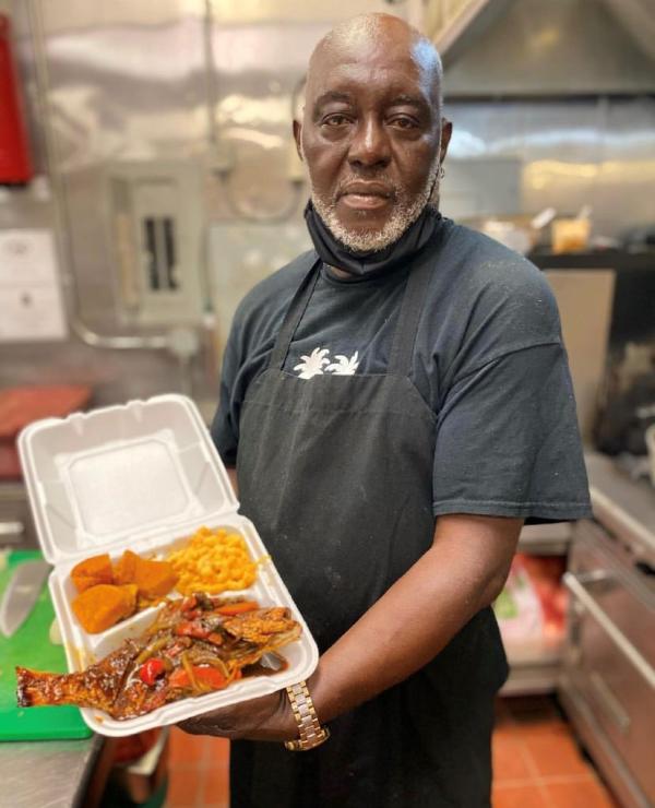 Man Holding A Box Of Food From Montego Island Grill In Virginia Beach, VA