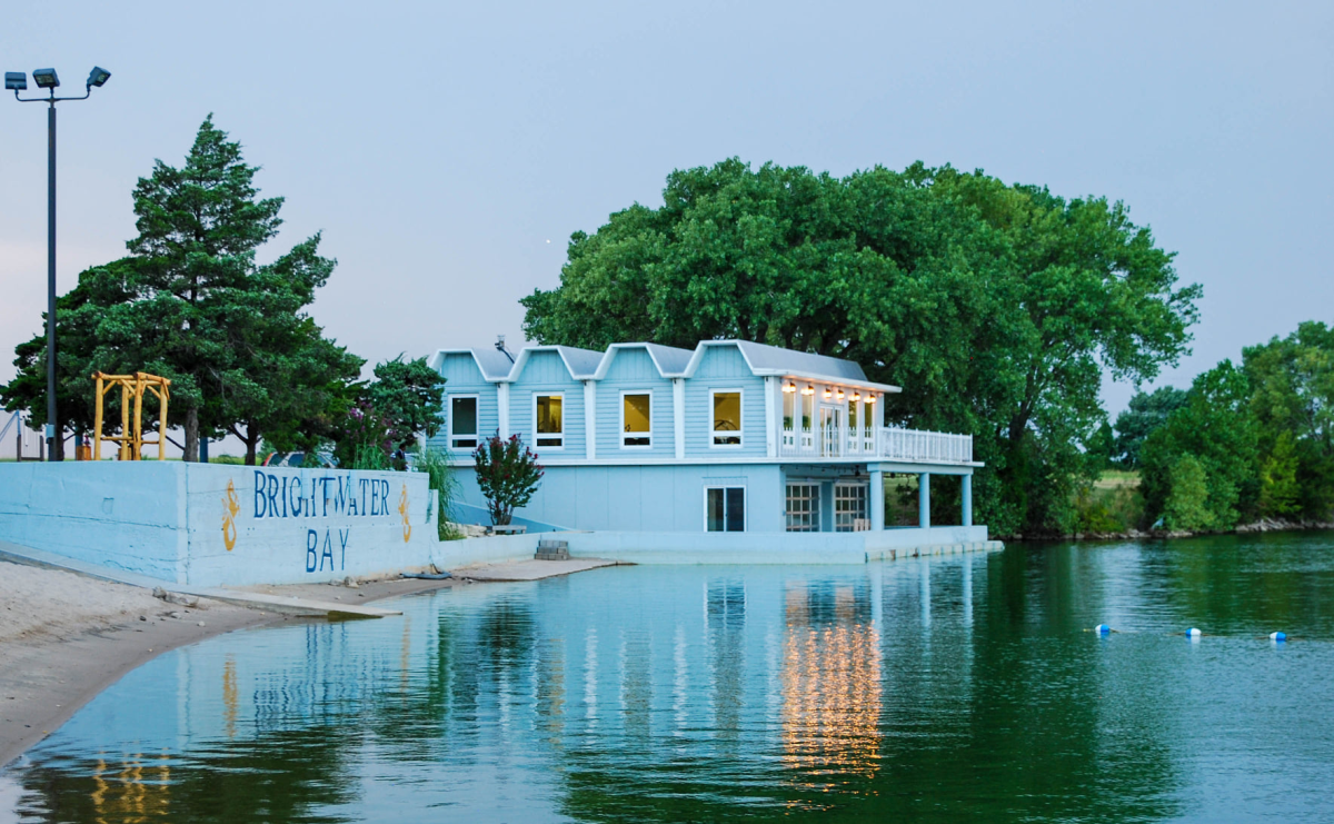 The exterior of the main property at BrightWater Bay is captured with calm waters at sunset in Wichita, KS