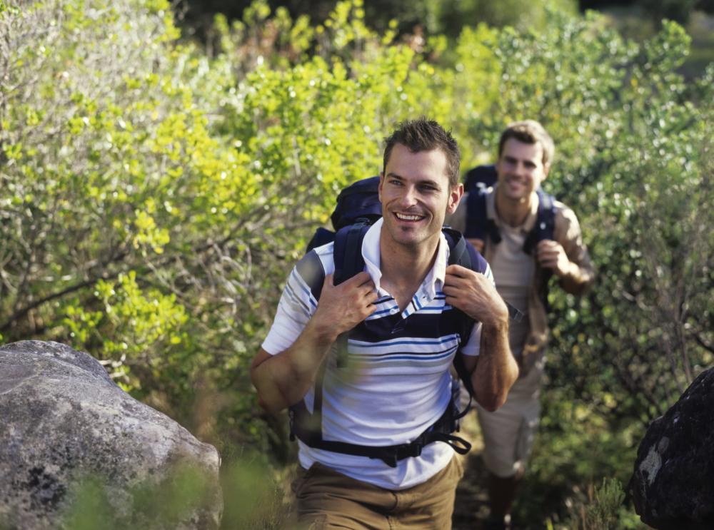 Two young men hiking with rucksacks, smiling