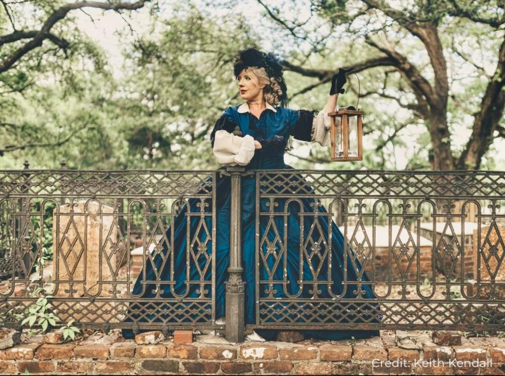 woman wearing an old Victorian dress in a graveyard