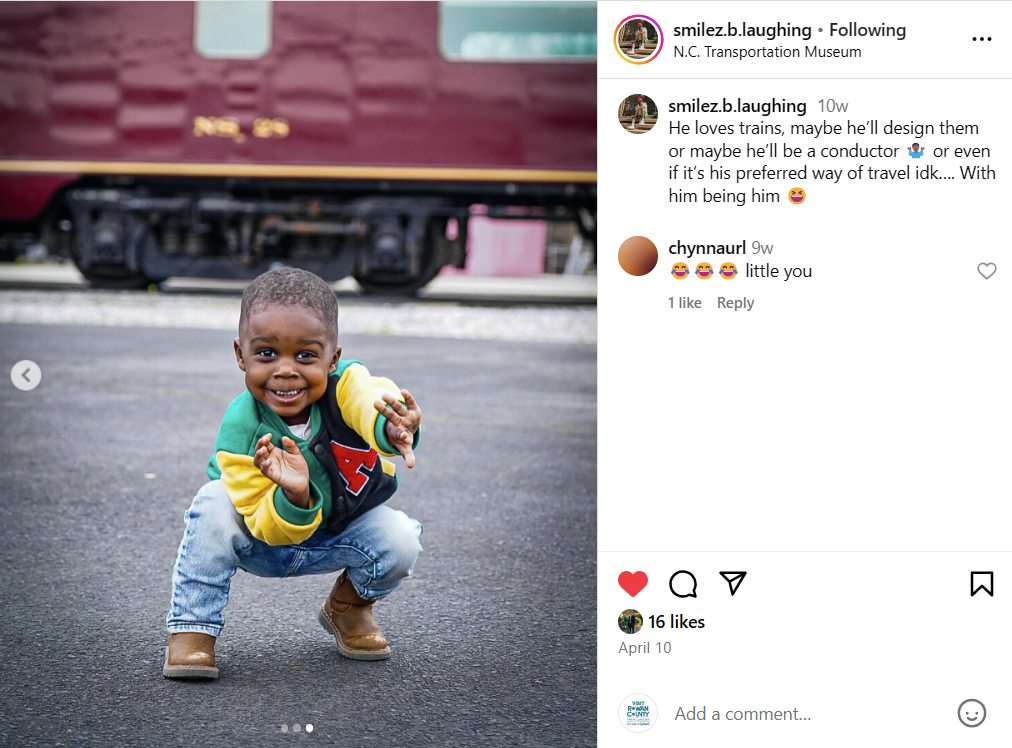 Boy posing in front of train