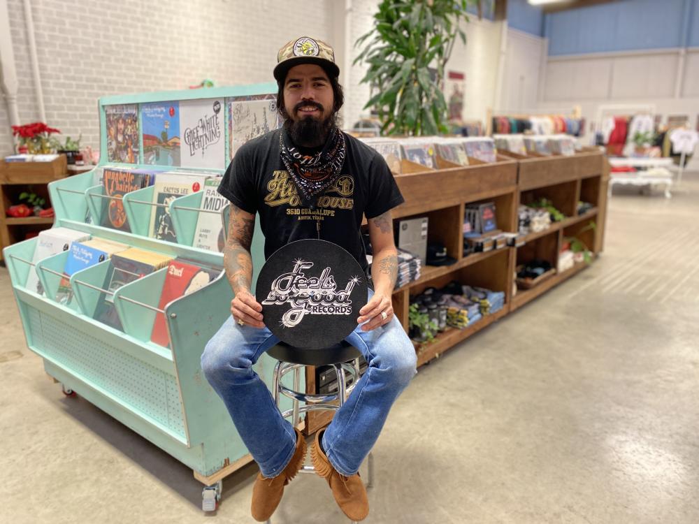 Man sitting on stool inside of Feels So Good Records Record Shop in Austin Texas