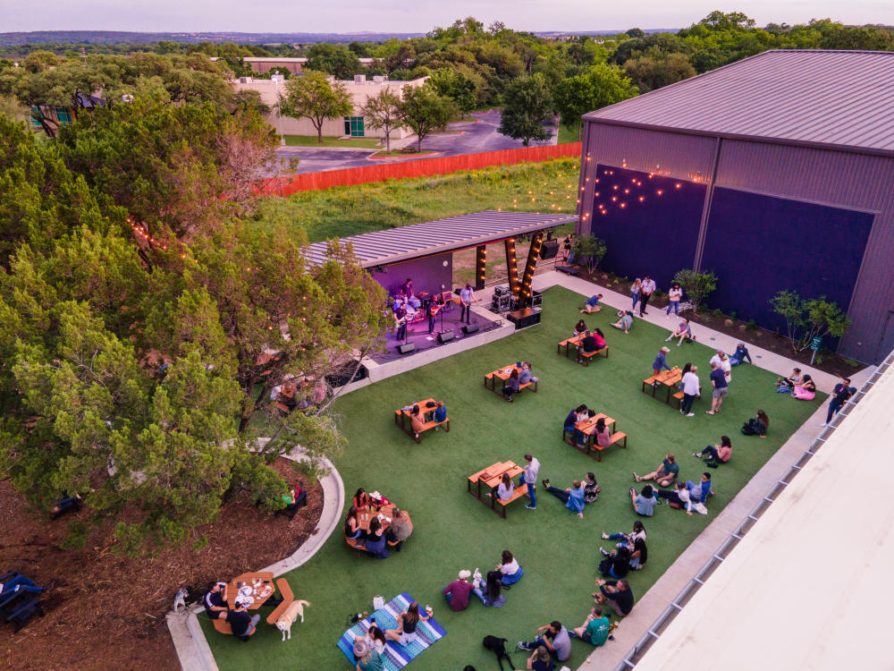 Aerial view of patrons enjoying the courtyard and live music at Meanwhile Brewing