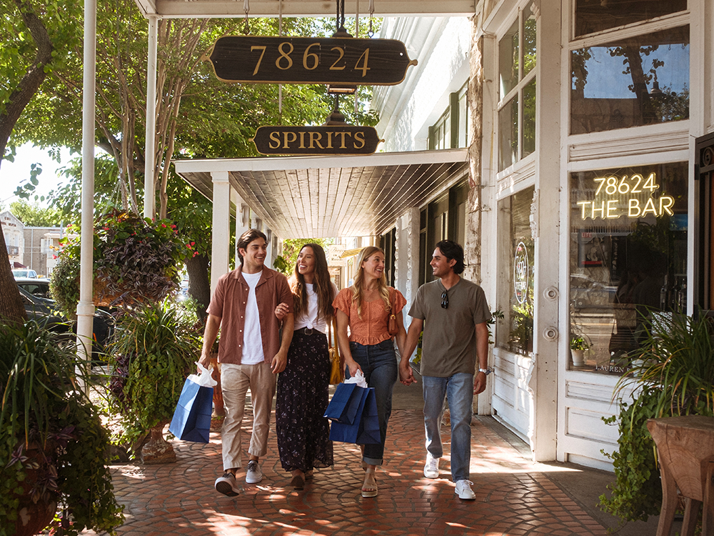Two couples walking with shopping bags on Fredericksburg's Main Street.