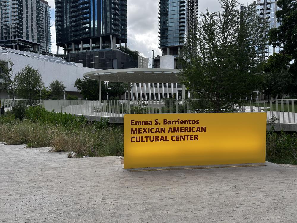 The exterior yellow sign outside of the Emma S. Barrientos Mexican American Cultural Center.