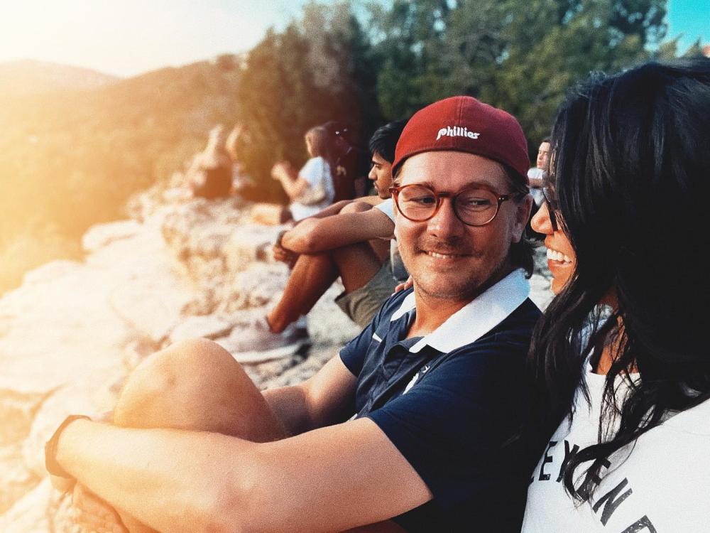 Couple looking lovingly at each other, sitting on the limestone rocks at Mount Bonnell.