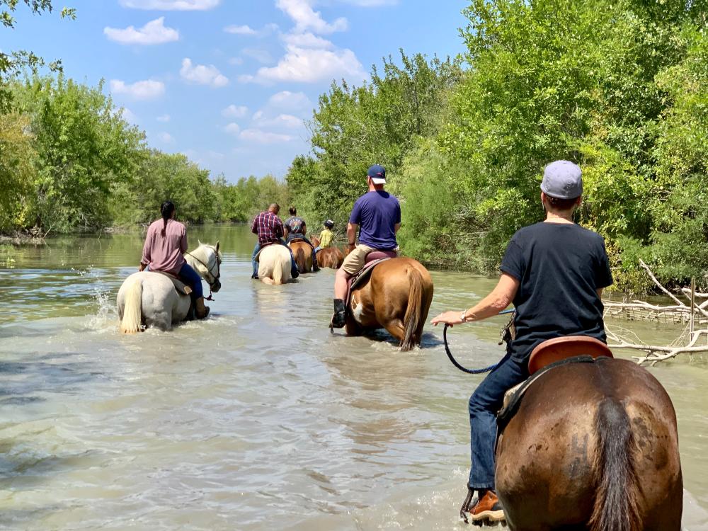 horseback riding through creek with Maverick Horseback Riding in Lockhart near Austin Texas