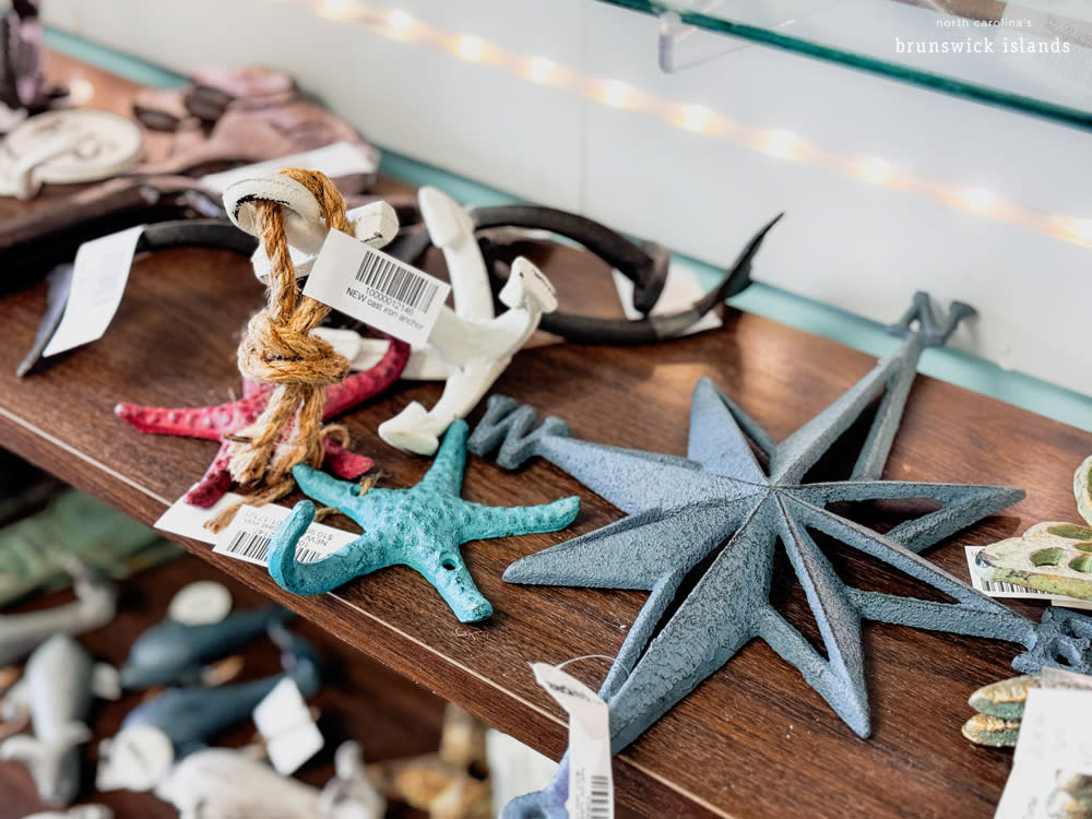 metal starfish and compass decorations on a shelf