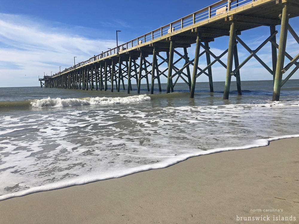 a view from the beach of a pier extending into the ocean