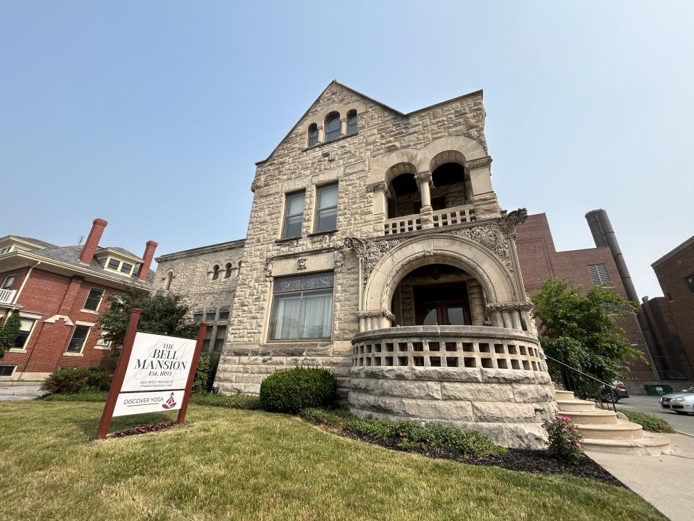 Front of the Bell Mansion, an impressive stone structure with round stone patio