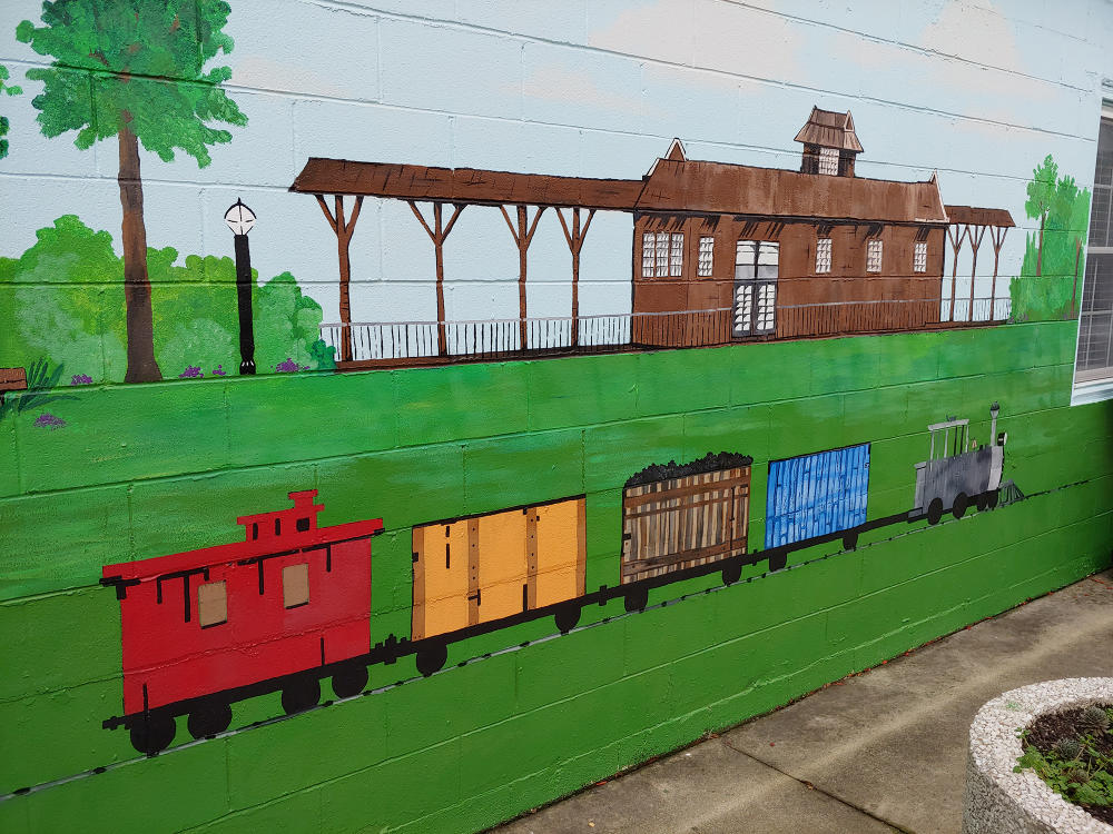 A mural of a train in front of a train station in Selma's Vick Park