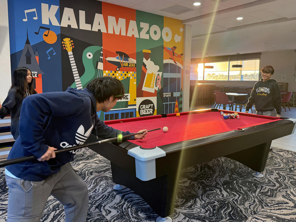 Two boys play pool at the Home2 Suites in Kalamazoo, MI