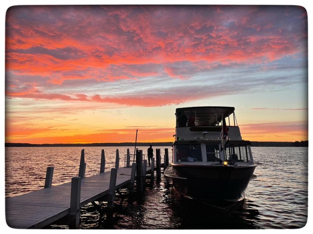 Image of the boat that takes visitors to Black Point Estate and Gardens at sunset.