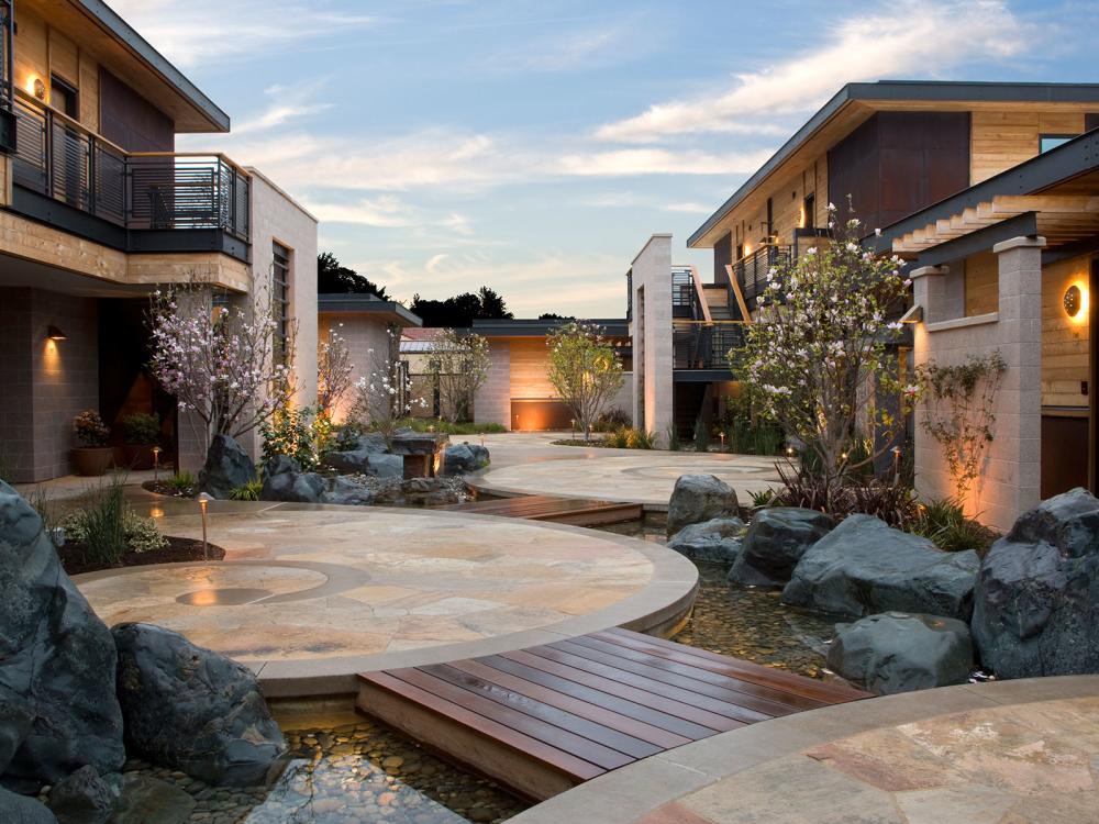 A walking path at Bardessono hotel with circular concrete pads, with small wooden bridges connecting them.