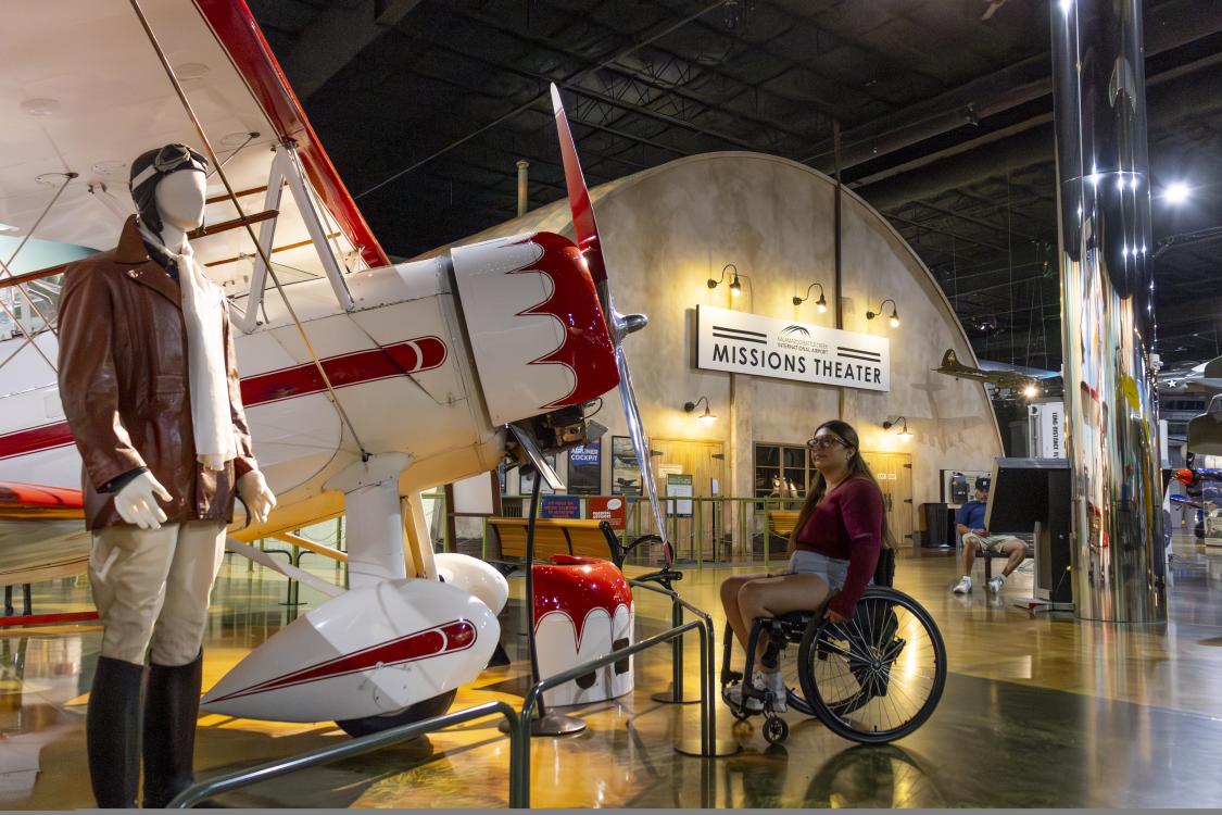 A woman in a wheelchair admires an airplane located at the Air Zoo in Portage, MI.
