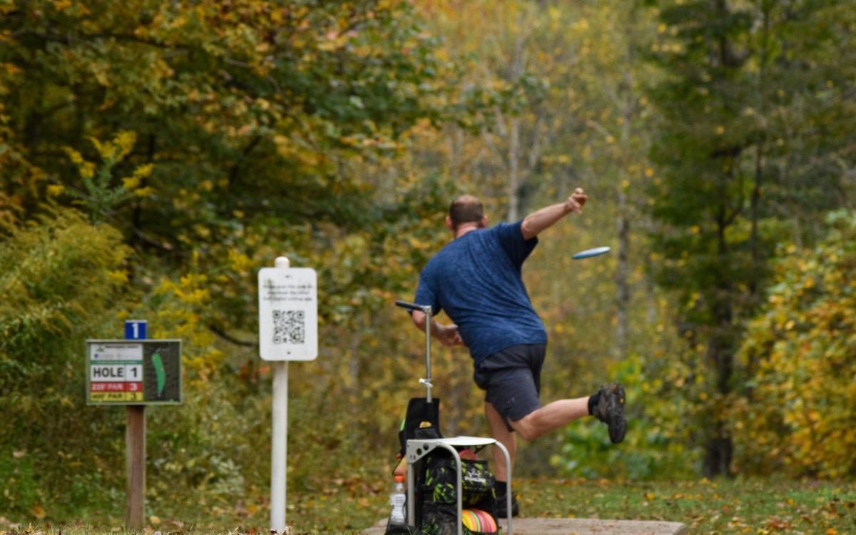 Man throwing disk golf at Rotary Park
