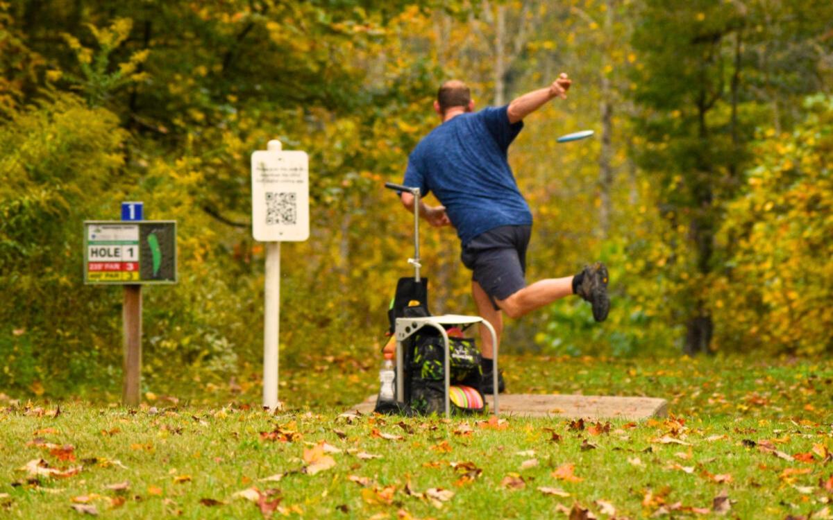 Man throwing disk golf at Rotary Park