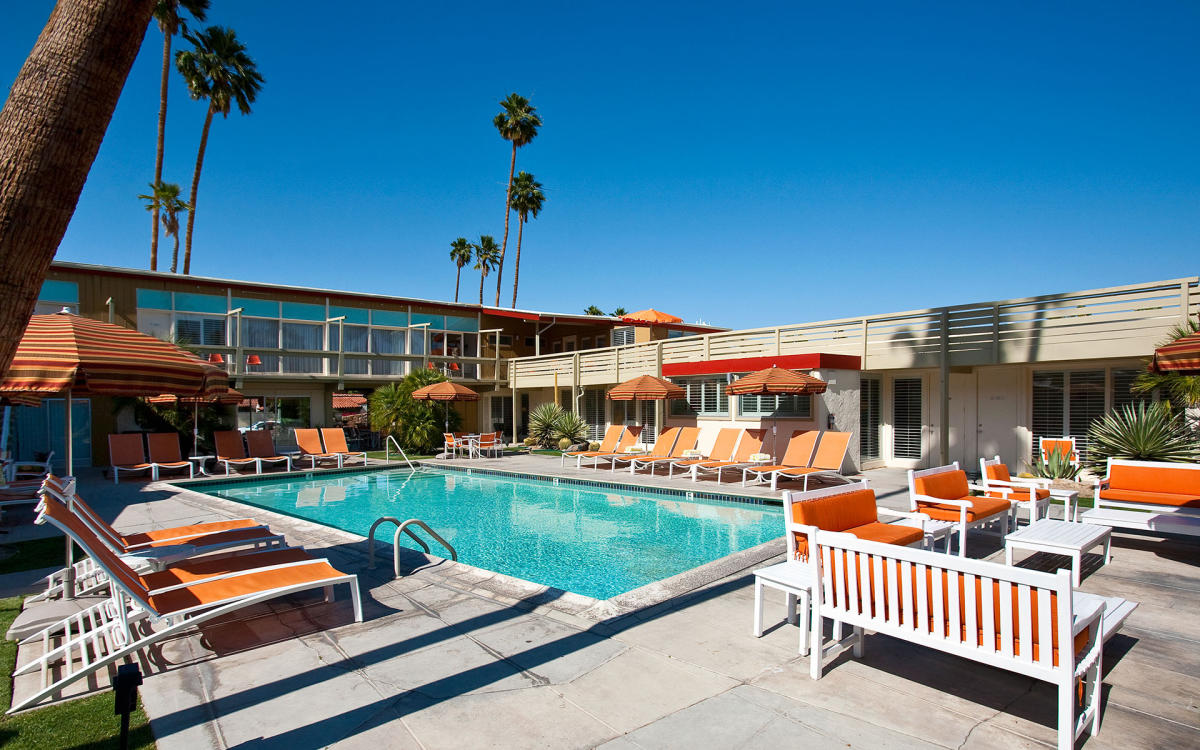 Beautiful boutique hotel with blue pool and orange pool chairs