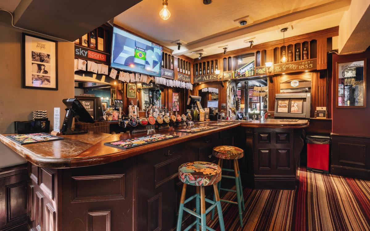 Inside of The Grapes pub and accommodation. Shot of an empty bar with stools and taps.