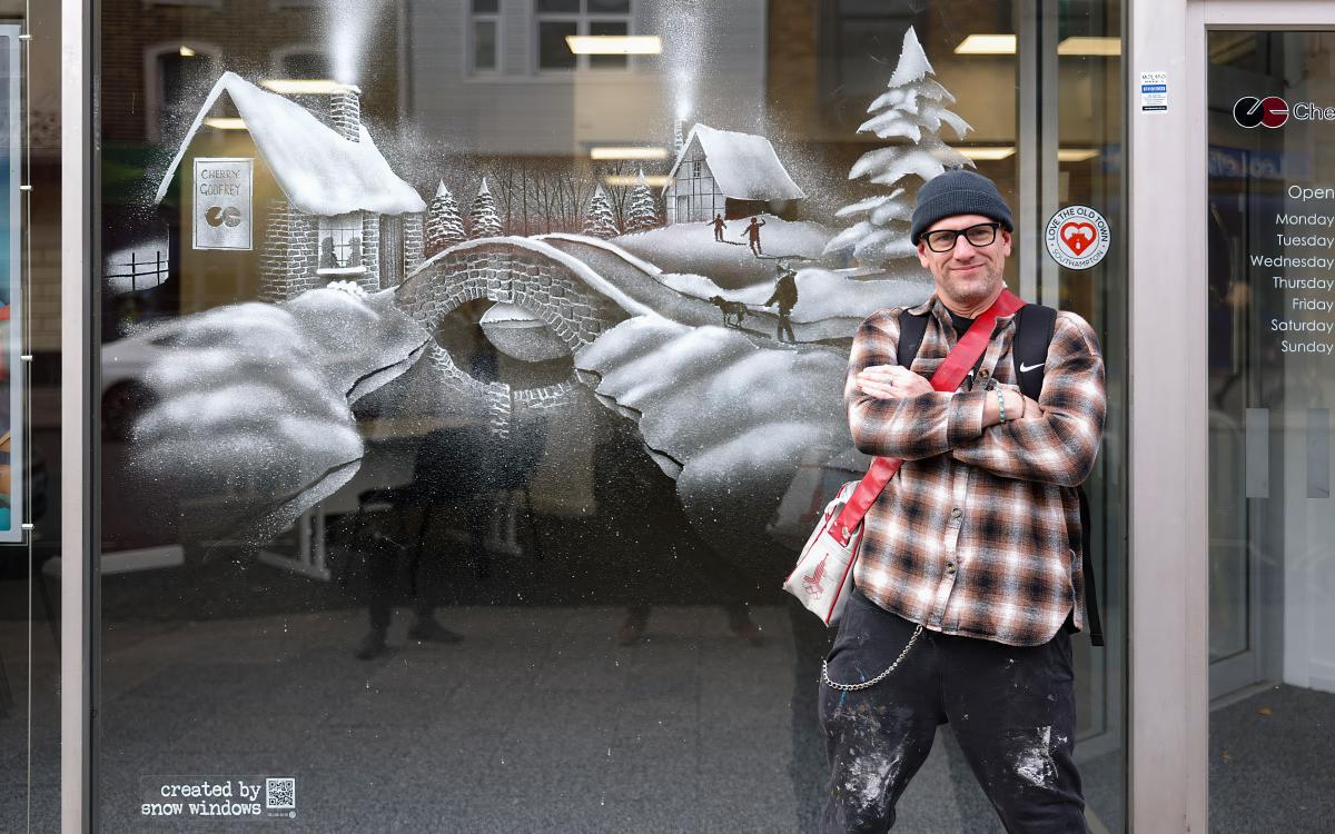 Tom Baker, Snow Windows artist standing in front of winter snow scene at Cherry Godfrey